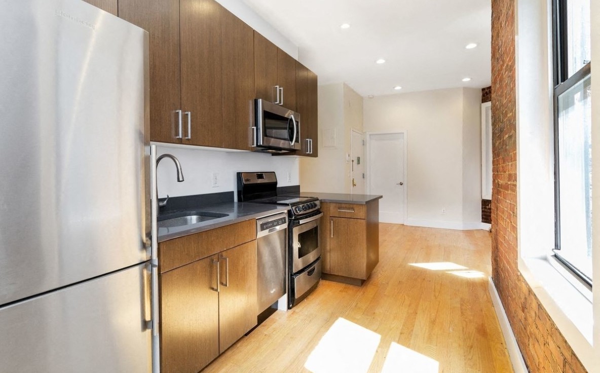 A kitchen with wooden cabinets and stainless steel appliances.