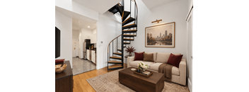 A living room with a spiral staircase and a painting on the wall.
