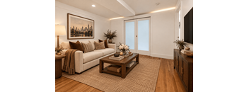 A living room with a couch, coffee table, and a painting on the wall.