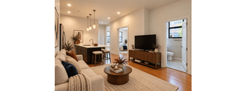 A living room with a couch, a coffee table, and a television.