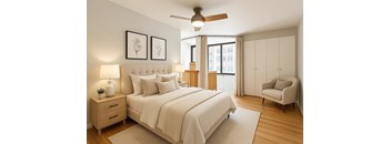 A bedroom with a large bed, a chair, and a ceiling fan.