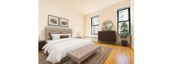 A bedroom with a large bed and a bench in front of it.