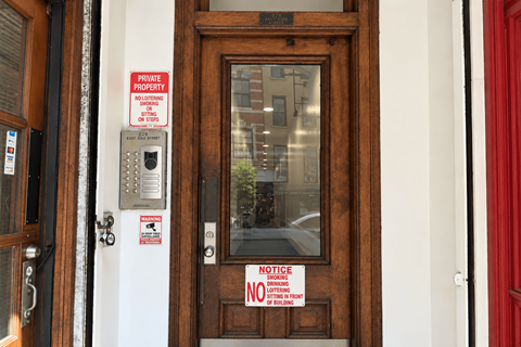 A brown door with a red sign on it.