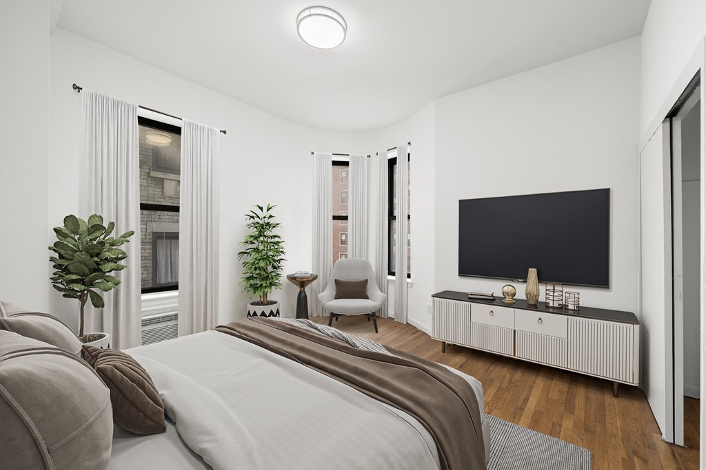 A modern bedroom with a large bed and a flat screen TV.