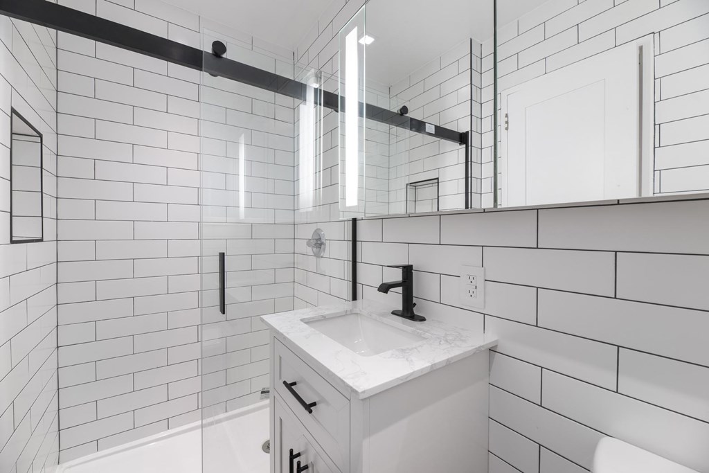 A white bathroom with a white sink and a white toilet.
