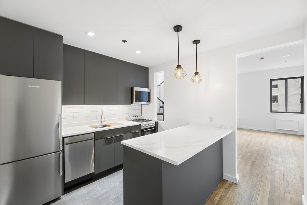 A modern kitchen with a refrigerator, sink, and cabinets.