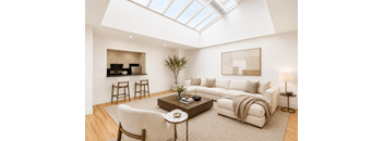 A living room with a white couch, a coffee table, and a skylight.