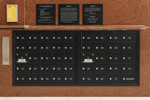 A wall with a series of black plaques and a keypad with numbers and letters.