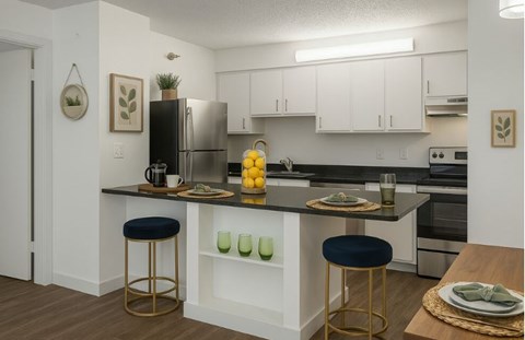 A kitchen with white cabinets and a black countertop.