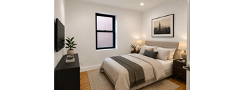 A bedroom with a large bed, a window, and a framed picture on the wall.