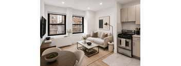 A modern living room with a white couch, a wooden coffee table, and a kitchen area with stainless steel appliances.
