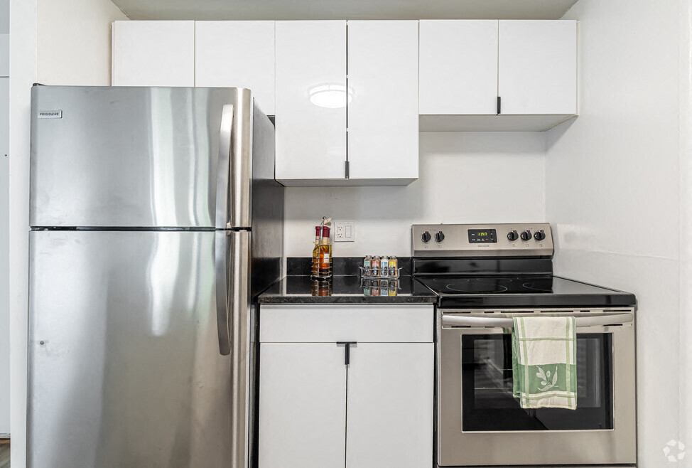 A modern kitchen with a stainless steel refrigerator and oven.