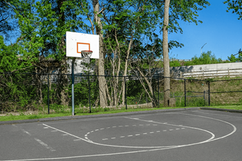 A basketball court with a hoop and a backboard.