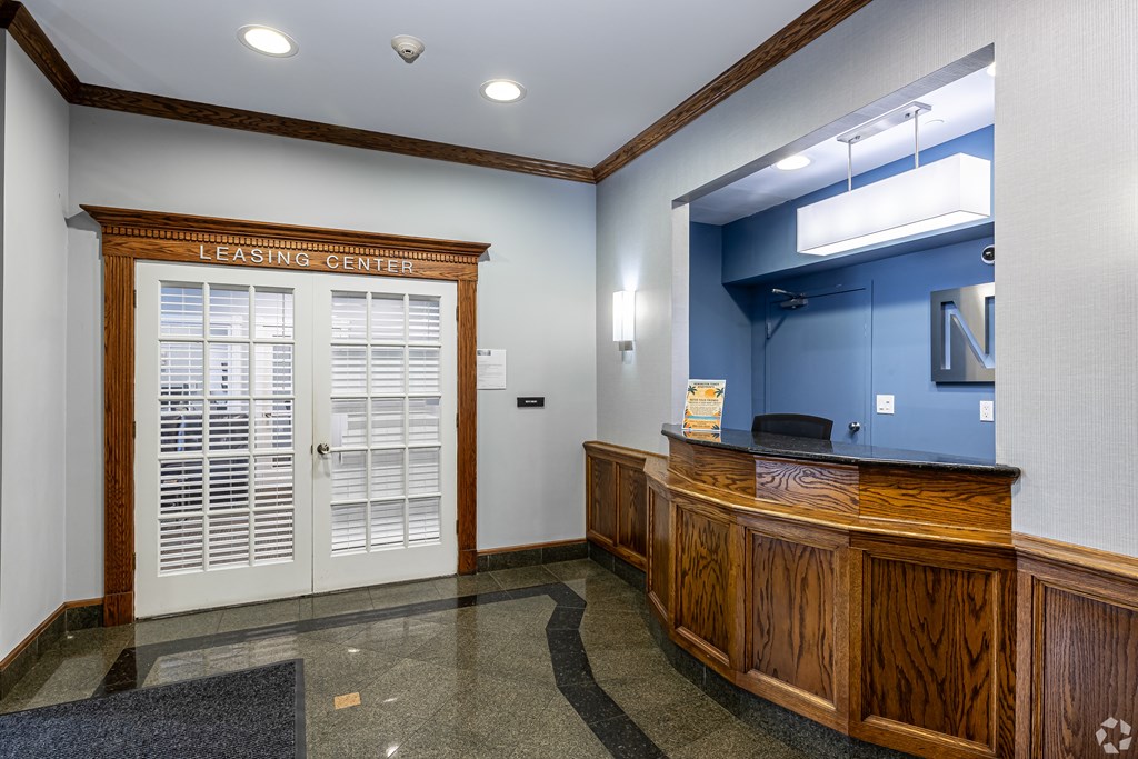 A leasing center office with a blue wall and a wooden desk.