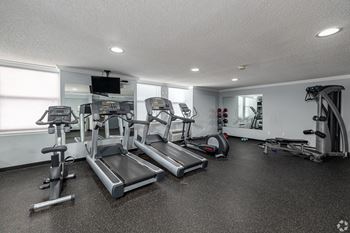 A well-equipped gym with treadmills, exercise bikes, and other cardio machines.