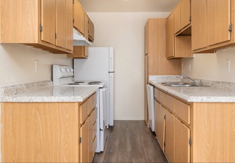 A kitchen with wooden cabinets and a white fridge.