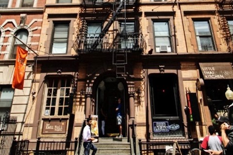 A brown building with a black fire escape.