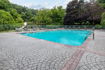 A large outdoor swimming pool surrounded by trees.