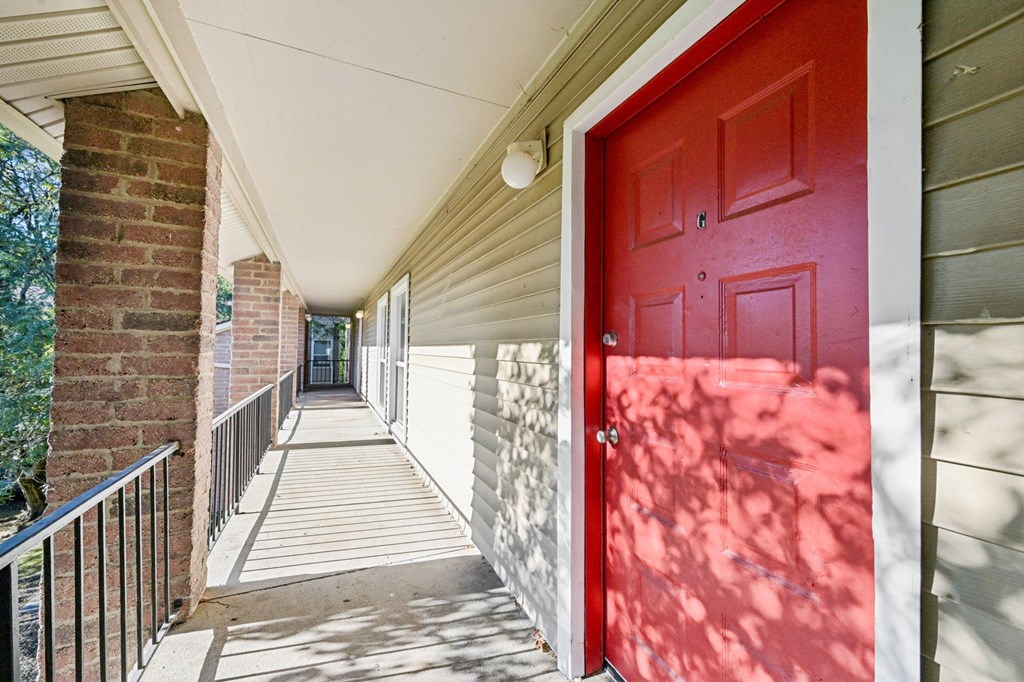 A red door is on the right side of a white wall.