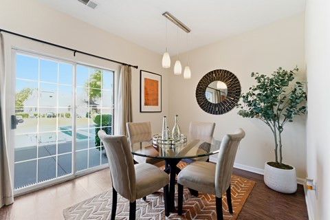 A dining room with a glass table and chairs.