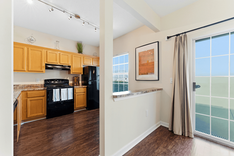 A kitchen with wooden cabinets and black appliances is shown.