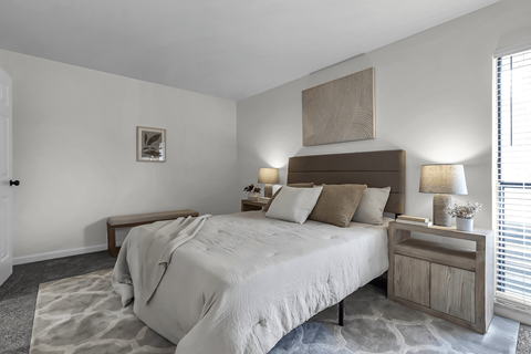 A bedroom with a large bed and a wooden headboard.