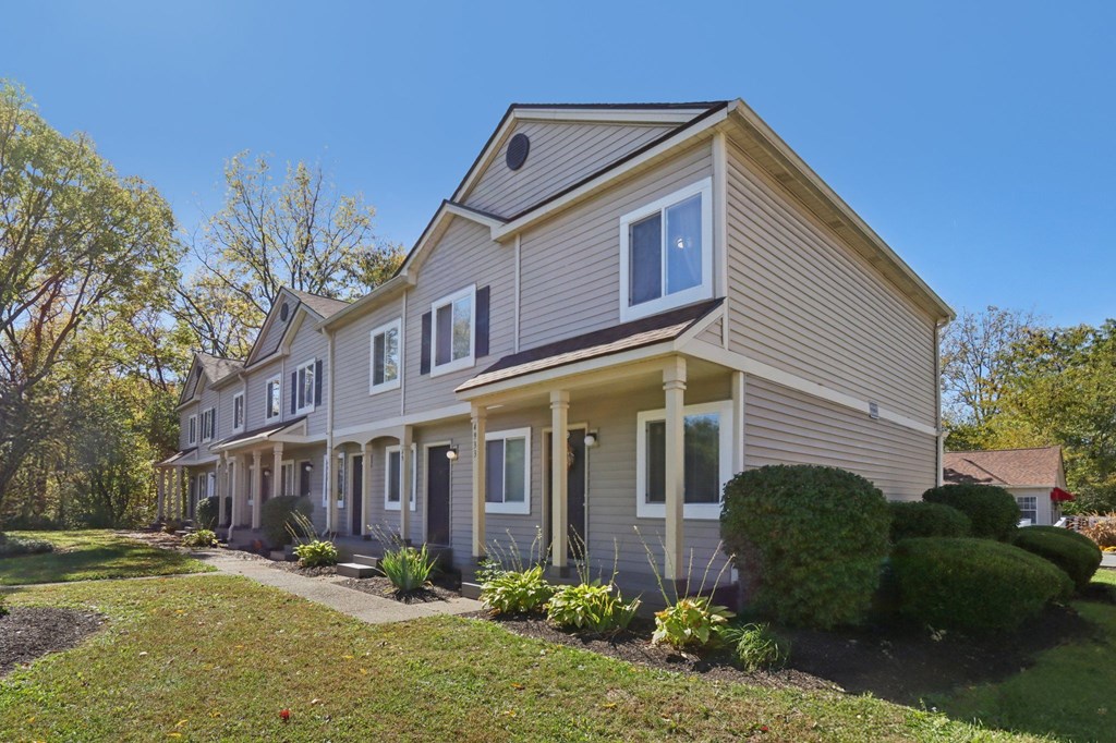 A house with a grey facade and a brown roof.