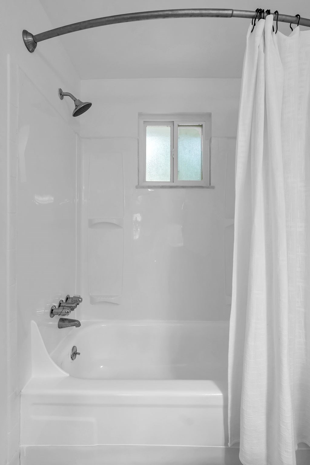 A white bathroom with a tub and shower.
