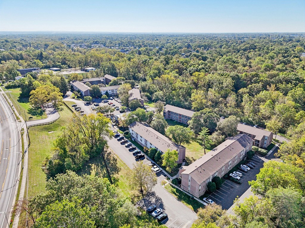An aerial view of a parking lot and buildings surrounded by trees.