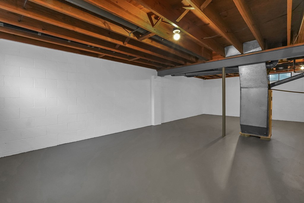 A white wall with a wooden beam on the ceiling.