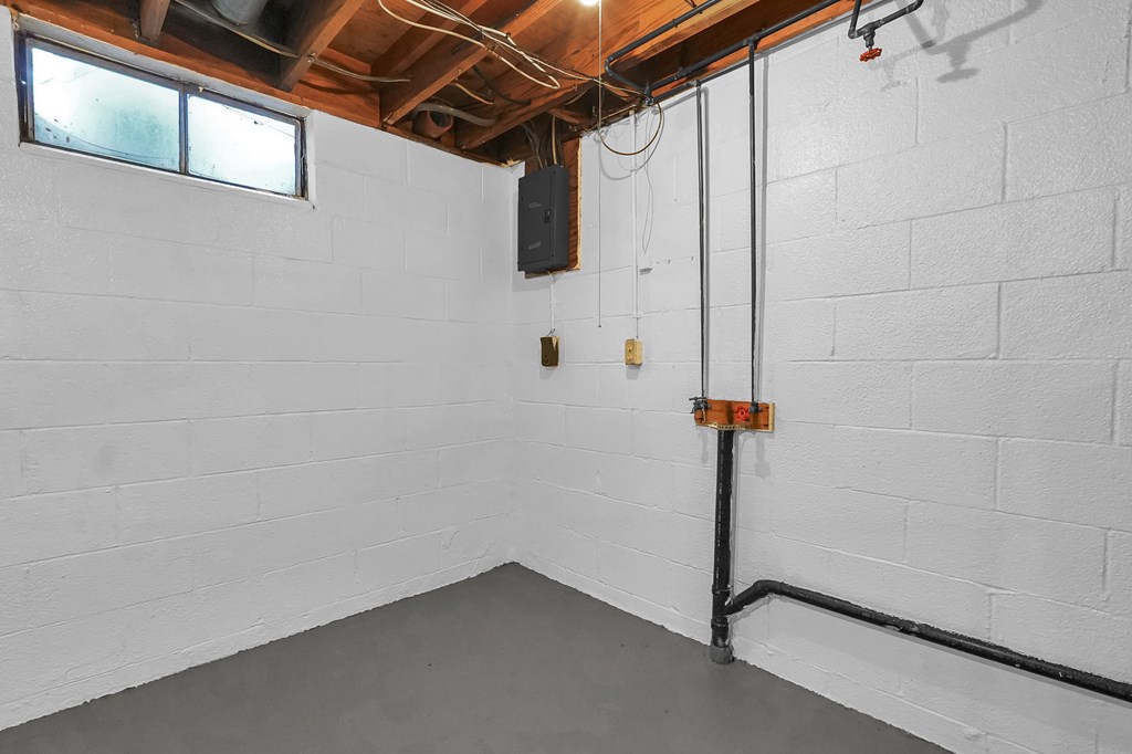 A white room with a window and a black pipe running along the floor.