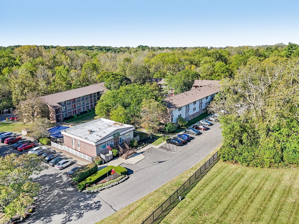 A parking lot is in front of a building with a flag on it.
