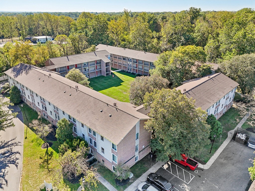 A large apartment complex with a parking lot in front.