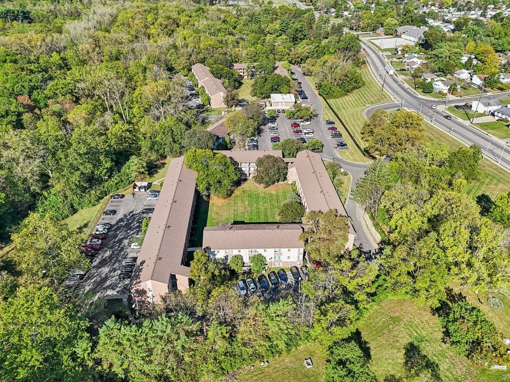 A large building surrounded by trees and a parking lot.