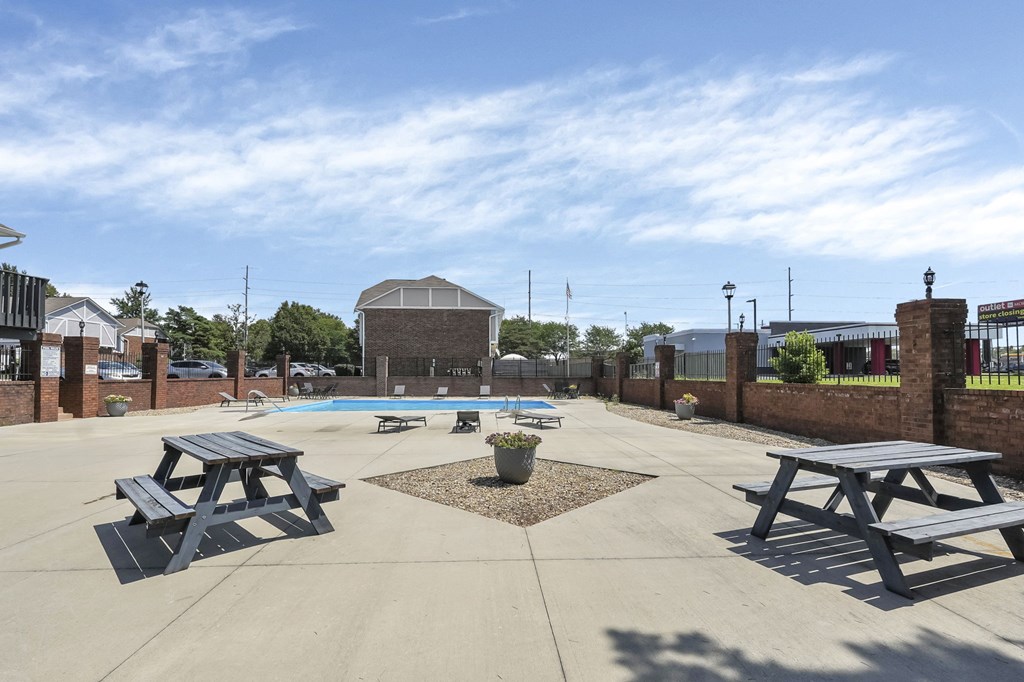 A sunny day at the outdoor picnic area with tables and a pool.