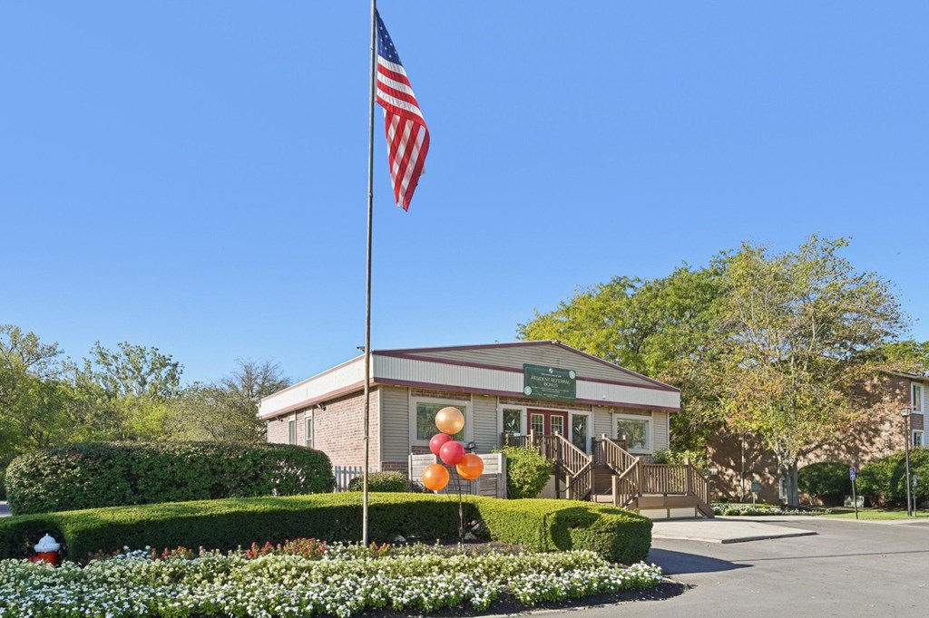 A building with a flag on top and balloons in front.