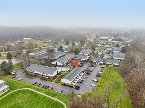 A large building complex with a parking lot in front.