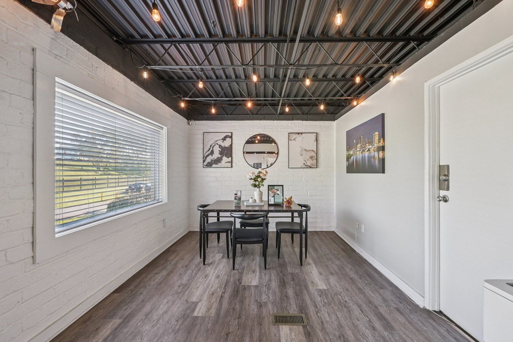 A dining room with a table set for two and a window with blinds.