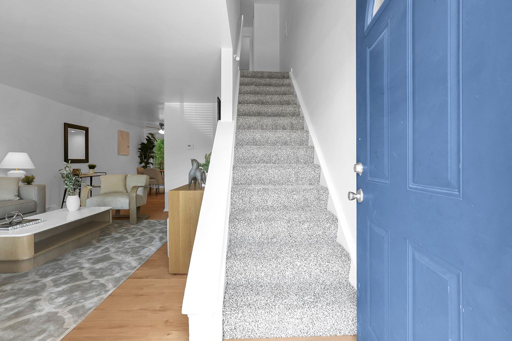 A blue door is on the right side of a staircase.