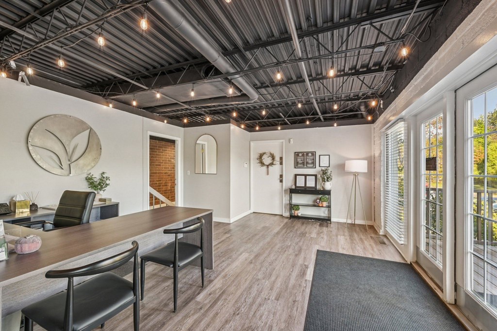 A room with a wooden floor and a long table with chairs.