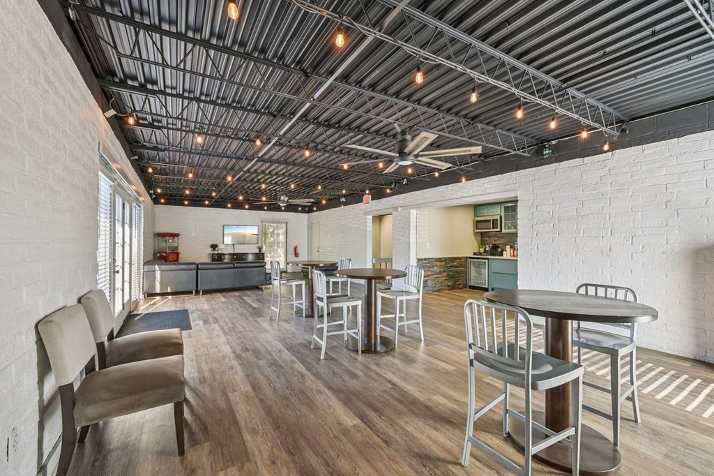 A modern open plan living and dining area with a kitchen in the background.