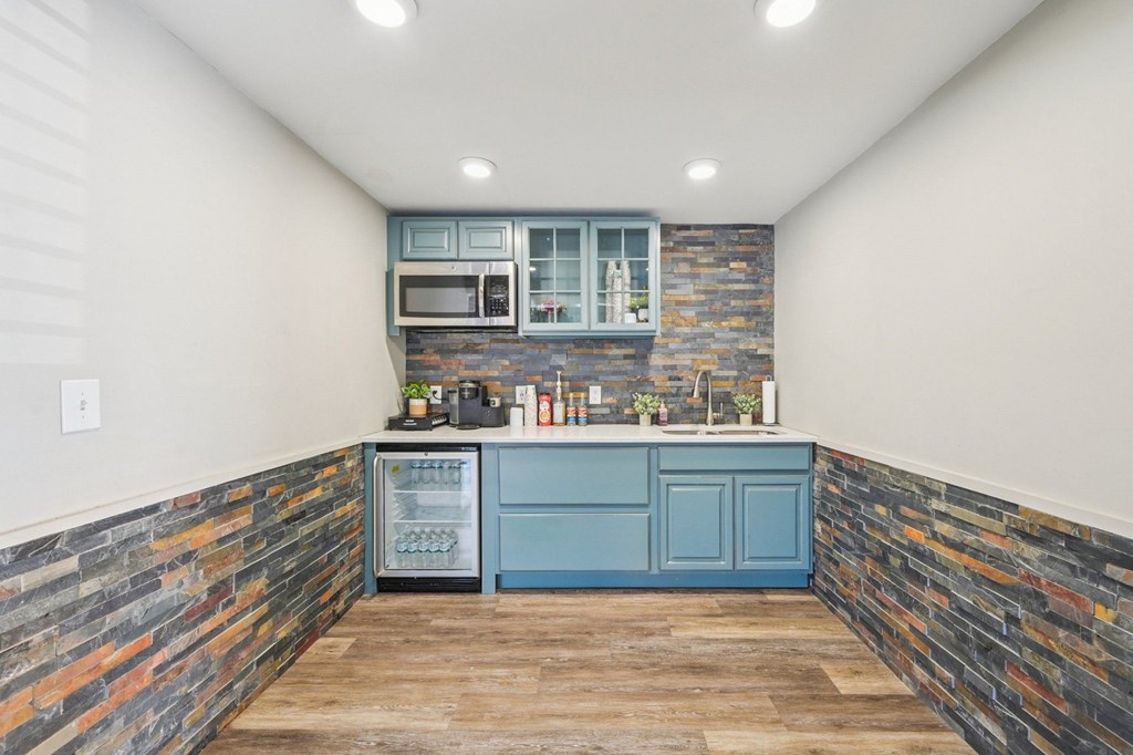 A kitchen with a blue cabinet and a stone wall.