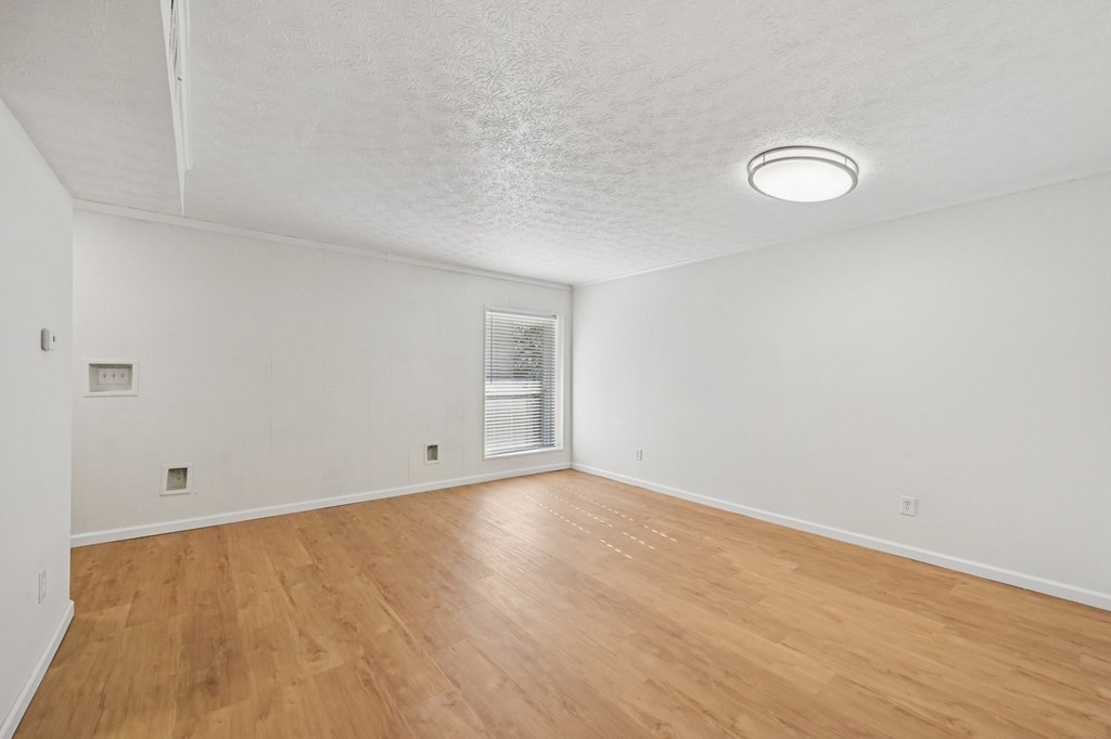 A room with wooden flooring and a white ceiling.