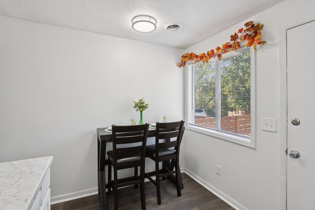 A small dining room with a table and chairs.