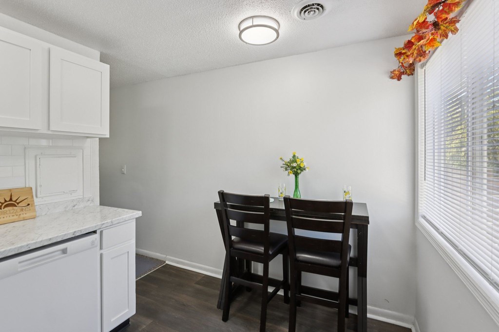 A kitchen with a table and chairs.