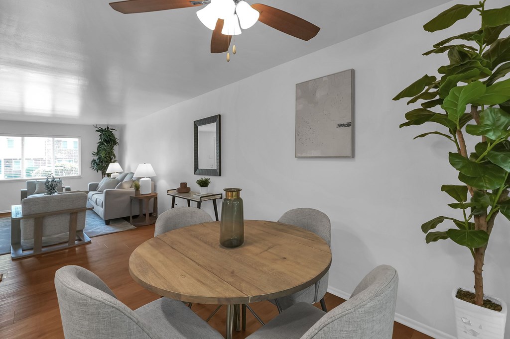 A living room with a wooden table and grey chairs.