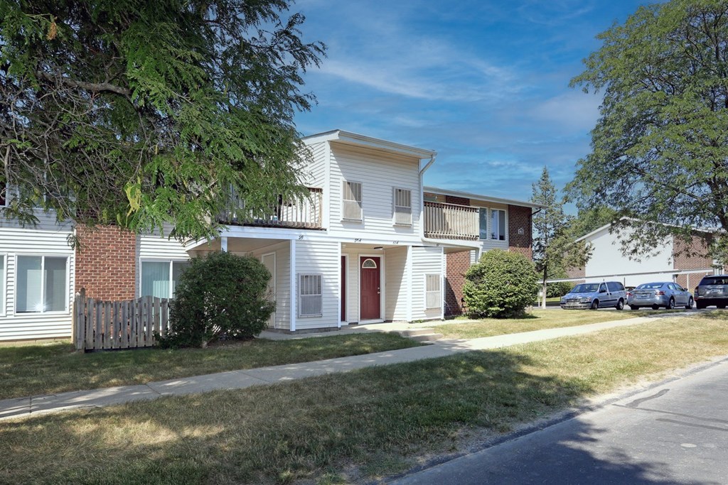 a white house with a sidewalk in front of it