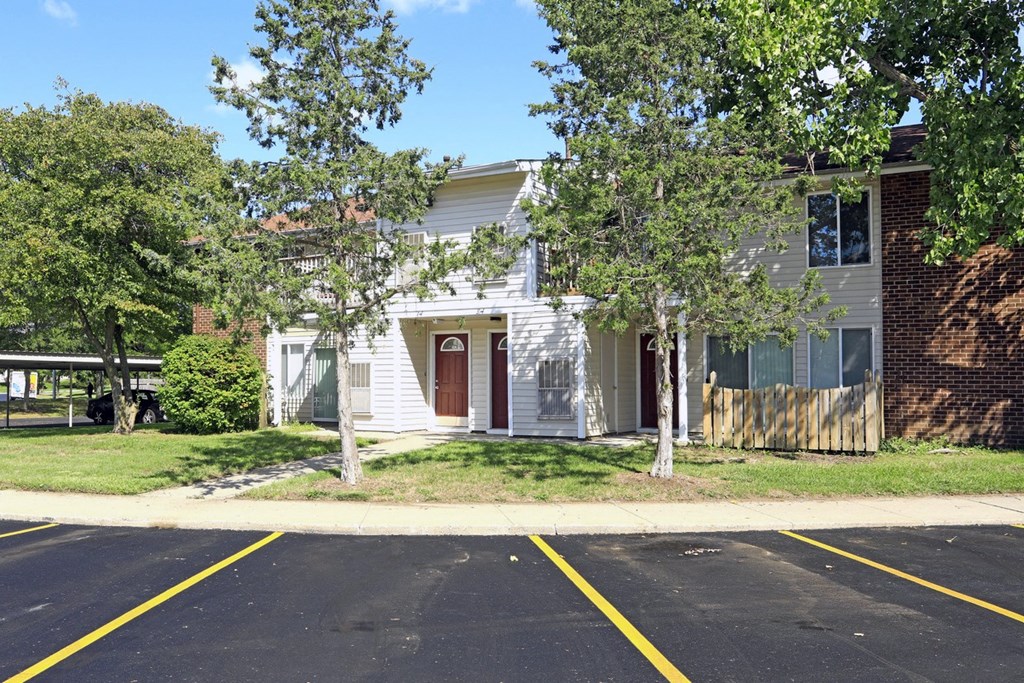 the front of a white house with trees