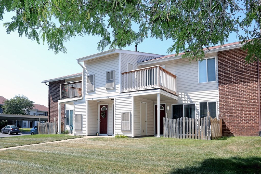 a white house with a balcony and a yard