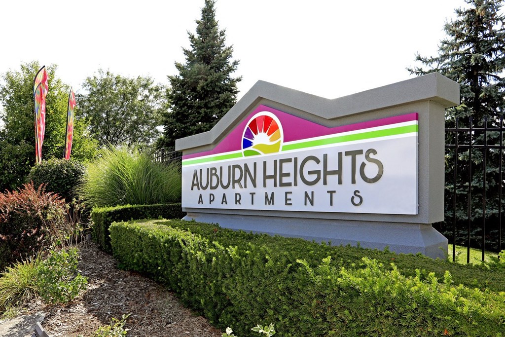 a sign for auburn heights apartments is shown in a garden